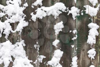 Snow on the wooden fence as a backdrop