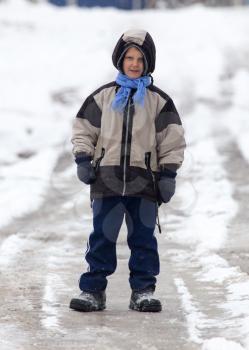 boy walking along the road in the winter