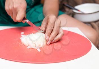 woman cuts onion knife