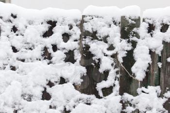 Snow on the wooden fence as a backdrop