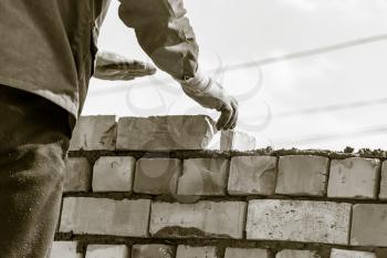 Worker builds a brick wall in the house .
