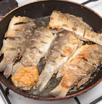 Fish carp is fried in a frying pan .