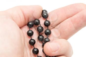 Black beads in hand on a white background .