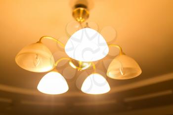 Burning lamps in a chandelier on the ceiling