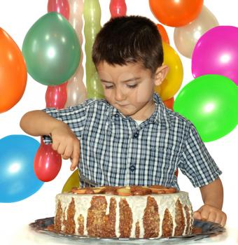Cute little boy celebrates his birthday and eat cake