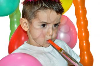 Little boy playing with air whistle and colorful balloons