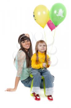 Mother and his daughters with colorful balloons. studio shoot over white background