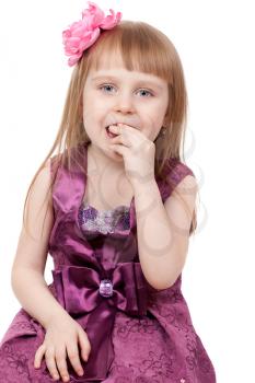 The little girl eats a jujube. Isolated on a white background