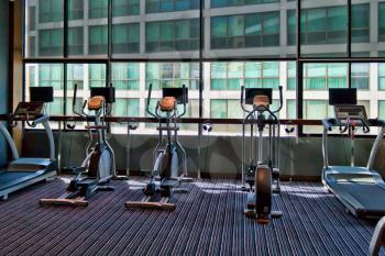 gym with large windows and a stationary bike