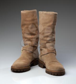 Pair of beige suede fashionable winter boots. Creative.