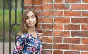 portrait of a beautiful young girl on a background of red bricks