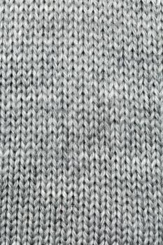Grey knitted background of natural wool closeup.