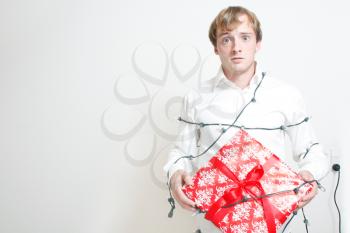 Royalty Free Photo of a Man Wrapped in Lights Holding a Present