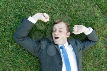 Royalty Free Photo of a Businessman Laying in Grass
