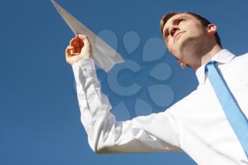 Royalty Free Photo of a Businessman Throwing a Paper Airplane