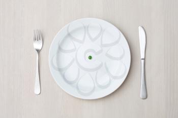 Royalty Free Photo of a Pea on a Plate Setting
