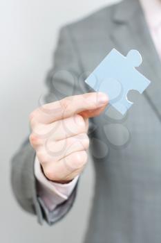 Royalty Free Photo of a Businessman Holding a Puzzle Piece