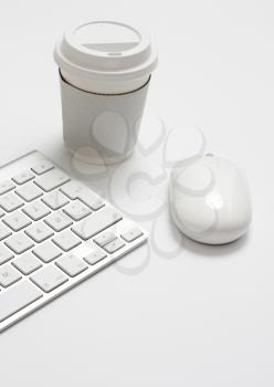 Royalty Free Photo of a Cup of Coffee Beside a Keyboard