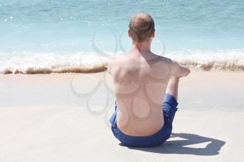 Royalty Free Photo of a Man Sitting at the Beach