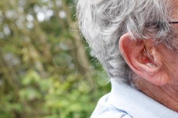 Royalty Free Photo of an Old Man Wearing a Hearing Aid
