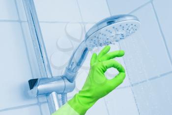 Cleaning shower with glove on