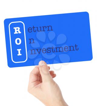 Return On Investment explained on a card held by a hand