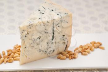 Royalty Free Photo of a Slice of Gorgonzola Cheese with Pine Nuts
