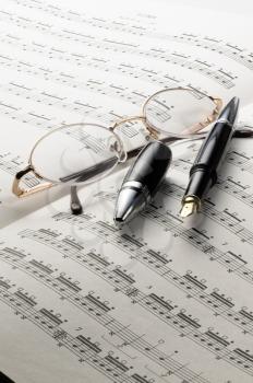 music charts with glasses and pen on top