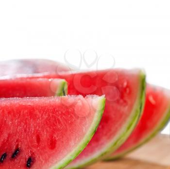 fresh ripe watermelon sliced on a  wood table over white background