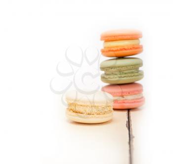 colorful french macaroons over a white rustic wood table 