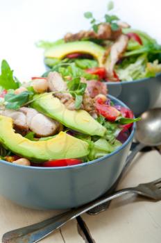 fresh and healthy Chicken Avocado salad over rustic wood table