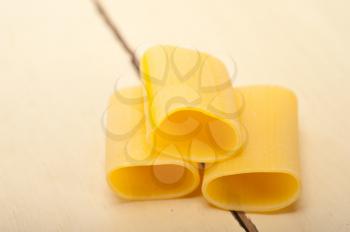 Italian pasta paccheri or schiaffoni macro closeup over white table