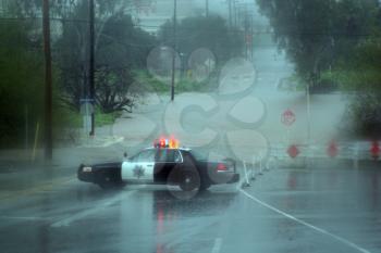 Royalty Free Photo of a Sheriff's Car Blocking A Flooded Road