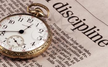 Royalty Free Photo of an Old Watch and the Business Section of a Newspaper