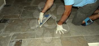 Royalty Free Photo of a Man Grouting and Putting in Ceramic Tile