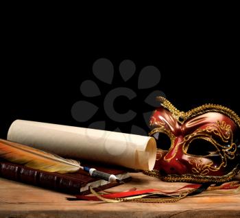 Royalty Free Photo of a Mask and Scroll on a Desk