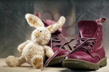 Royalty Free Photo of a Pair of Boots and a Toy Rabbit