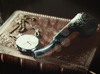 Abstract retro still life with old leather covered book and watch