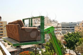 Royalty Free Photo of a Tractor Lifting a Couch