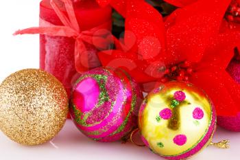 Christmas colorful balls with holly berry flowers and candle closeup image.