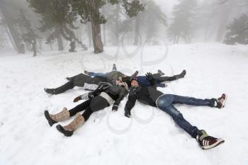 Pelople lying on snow in winter foggy day in Cyprus mountain Troodos.