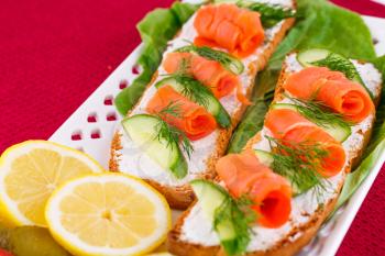 Royalty Free Photo of Smoked Salmon on Bread With Lemons and Pickles
