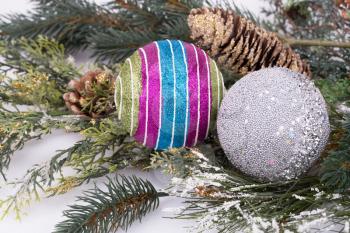 Christmas colorful balls, cones, fir-tree branch on gray background.