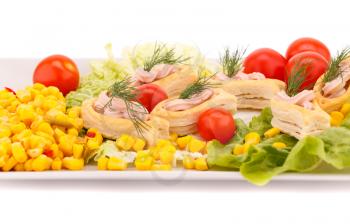 Fish cream in pastries, sweet corn, cherry tomato and lettuce on white plate.