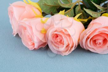 Pink fabric roses on cloth background, closeup picture.