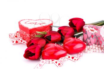 Red heart candles, tulips, necklaces and gift boxes on white backgroound.