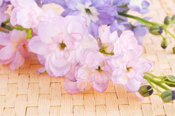 Pink fabric flowers on bamboo background, closeup picture.