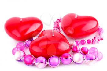 Red heart candles and pink necklace isolated on white background.