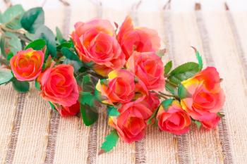 Colorful fabric roses on canvas background, closeup picture.