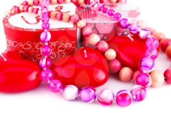 Red heart candles, necklaces and gift boxes on white background.